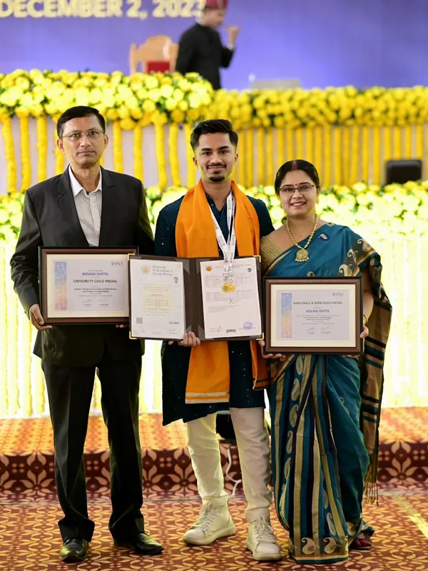 Kousik holding his two UPES gold medals with his parents at graduation
