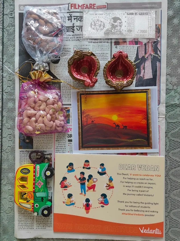 A handmade Diwali gift from Vedantu with diyas, artwork, flowers, sweets, and a note of gratitude